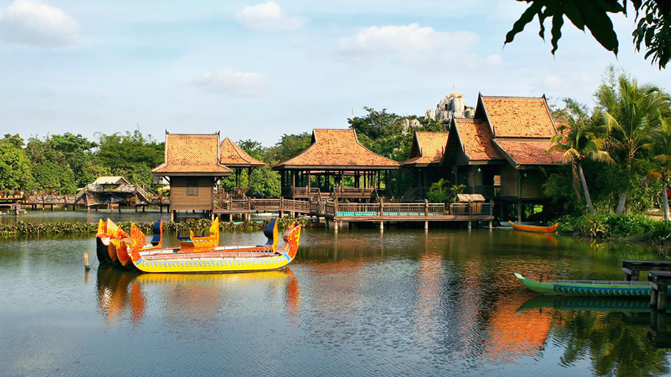 Traditional Khmer wooden houses and dragon boats on the lake at Cambodian Cultural Village in Siem Reap