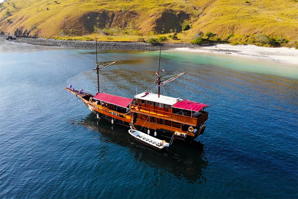 A wooden phinisi boat sailing near the islands of Komodo National Park