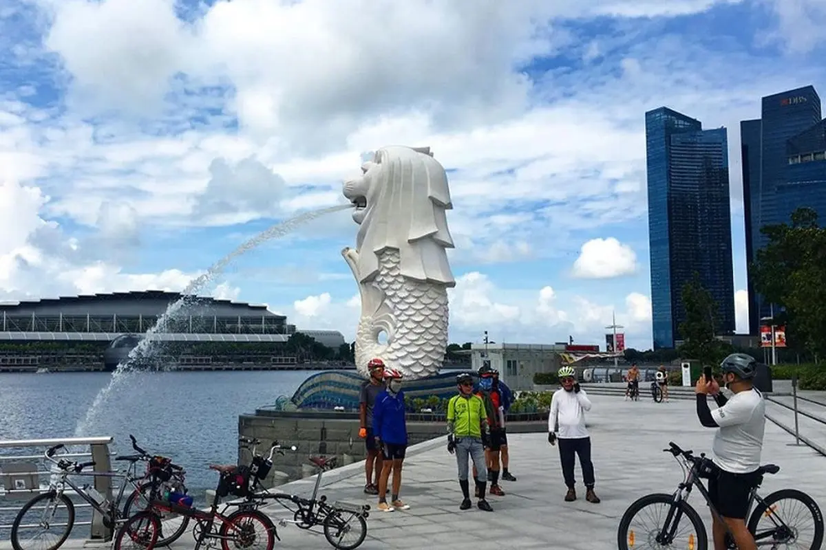Tourists taking pictures of the Merlion statue on a sunny day at Merlion Park.