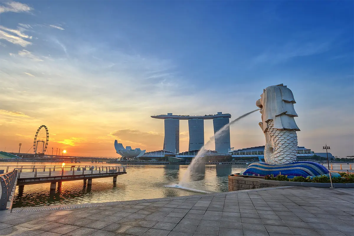 Merlion Park Singapore with the Marina Bay skyline in the background during sunset.