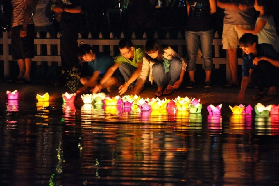 Visitors releasing paper lanterns on the Thu Bon River during Hoi An Full Moon Festival