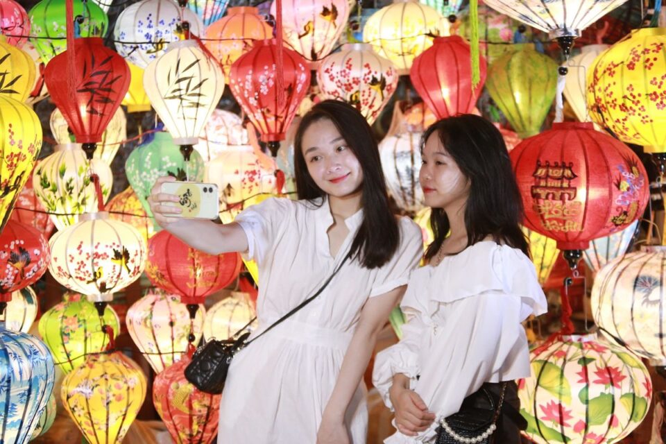 Tourist posing with silk lanterns during Full Moon Party in Hoi An