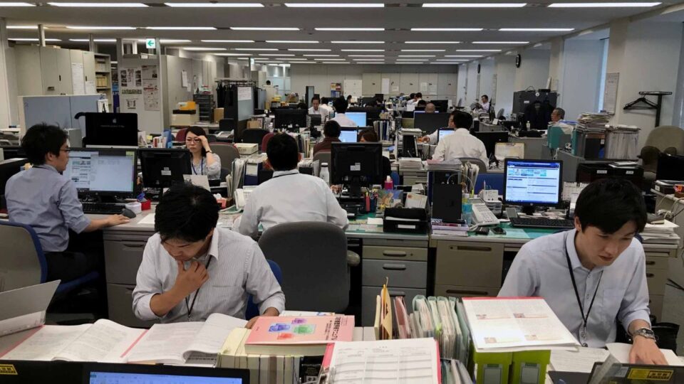 A conceptual infographic contrasting global work cultures. On one side, show stressed workers in Japan symbolizing “karoshi,” tech workers in Silicon Valley with glowing laptops symbolizing burnout, and a Chinese office worker under the 996 schedule. They appear tired, anxious, and overwhelmed. On the other side, illustrate peaceful scenes from France, Denmark, and the Netherlands: families enjoying dinner, people cycling in the city, and individuals relaxing in nature. In the background, a Shaolin monk meditates calmly, symbolizing balance and harmony. The overall style should be clean, modern infographic with soft colors and clear contrasts between stress and peace.