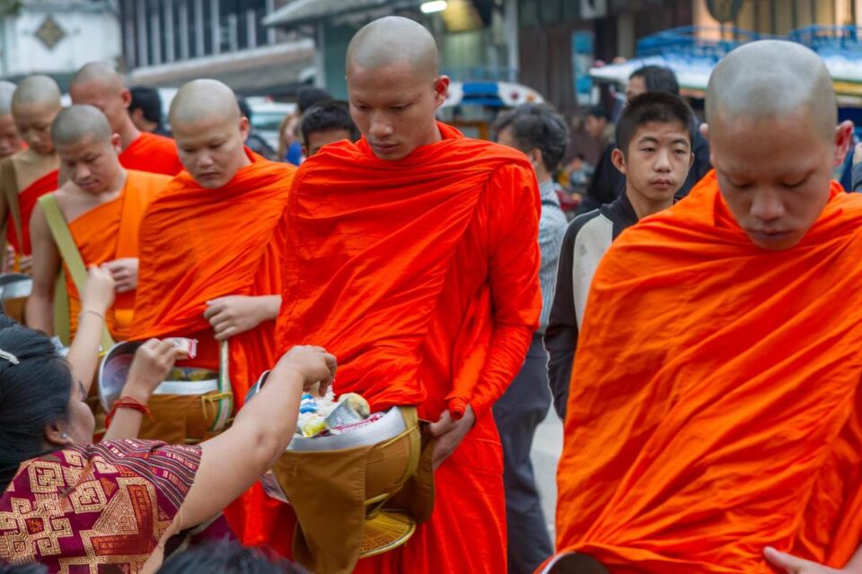 Monks receiving alms at That Luang Festival in Laos