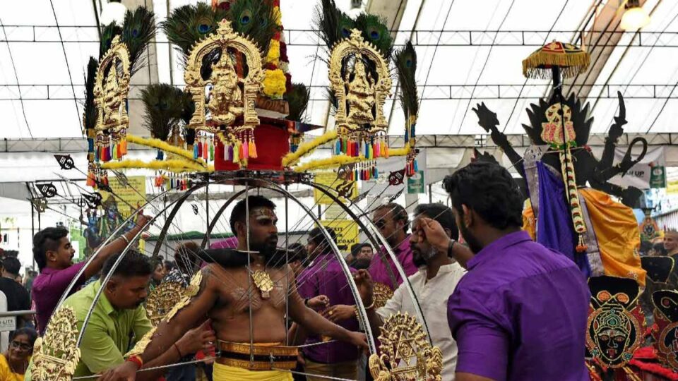 A Hindu devotee carrying an ornate Vel Kavadi with ritual piercings during Thaipusam.