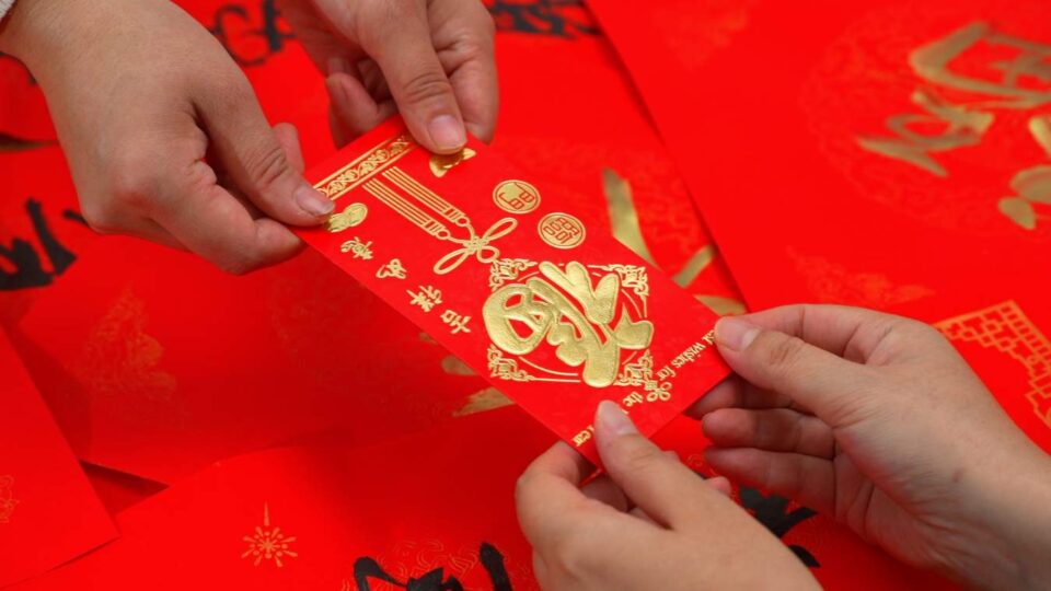 elegant red envelopes (Hongbao) with gold calligraphy on a festive background.